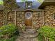 Charming stone home entry with a wooden door, stone steps, and manicured shrubs at 1050 E Club Ne Ln, Atlanta, GA 30319