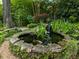 Backyard koi pond featuring stone edging, lush greenery, and a peaceful waterfall at 1050 E Club Ne Ln, Atlanta, GA 30319