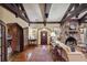 Living room with stone fireplace, hardwood floors, beams and entry to a dining area at 1050 E Club Ne Ln, Atlanta, GA 30319
