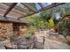 Stone patio with outdoor dining furniture and a trellis overlooking an enchanting manicured garden at 1050 E Club Ne Ln, Atlanta, GA 30319