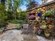Charming stone patio with colorful potted plants, a rocking chair, and access to a stone-clad building at 1050 E Club Ne Ln, Atlanta, GA 30319