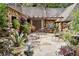 Spacious stone patio surrounded by lush greenery, outdoor furniture, and stone-clad architecture at 1050 E Club Ne Ln, Atlanta, GA 30319
