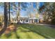 Charming brick home featuring manicured front lawn and mature trees on a sunny day at 2299 Brenda Se Dr, Smyrna, GA 30080