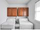 Well-equipped laundry room with dual washer and dryer units and built-in cabinets at 3281 Old Salem Rd, Conyers, GA 30013