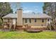 Back exterior view of a tan colored home with a deck and backyard at 845 James Path Ct, Lawrenceville, GA 30044
