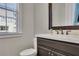 This half bathroom has a dark vanity and a toilet with a window offering natural light at 971 Thibideau Ct, Sandy Springs, GA 30328
