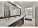 Bathroom with a double vanity, large mirror, and view of a bedroom and walk-in closet at 971 Thibideau Ct, Sandy Springs, GA 30328