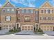 Charming townhome exterior with brick and stone accents, multi-car garage, and neat landscaping at 971 Thibideau Ct, Sandy Springs, GA 30328
