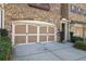 Attached garage with stylish white and brown door, complemented by manicured landscaping at 971 Thibideau Ct, Sandy Springs, GA 30328