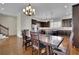 This open kitchen and dining area has dark wood cabinetry, granite counters, stainless steel appliances and wooden floors at 971 Thibideau Ct, Sandy Springs, GA 30328