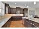 This kitchen has dark wood cabinetry, granite counters, stainless steel appliances and wooden floors at 971 Thibideau Ct, Sandy Springs, GA 30328