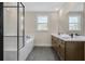 Bright bathroom featuring double vanity, soaking tub with glass enclosure, and window with natural light at 2568 Silver Star Ne Dr, Marietta, GA 30066