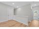 Second-floor hallway with natural light, neutral tones, and hardwood flooring at 2568 Silver Star Ne Dr, Marietta, GA 30066