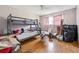 Bedroom featuring bunk beds, a window with pink curtains, and wood laminate flooring; needs decluttering at 270 Oak Ridge Rd, Covington, GA 30016