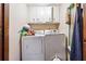 Compact laundry room with a white washer and dryer, plus overhead cabinets for storage at 270 Oak Ridge Rd, Covington, GA 30016