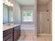 Bright bathroom with a combination tub and shower, dark wood vanity, and a window at 293 Depot Landing Rd, Auburn, GA 30011