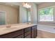 Bathroom with double sinks, a soaking tub under a window, and neutral color palette at 293 Depot Landing Rd, Auburn, GA 30011