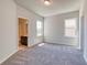 Bedroom with carpeted floors, neutral paint, and a view into an adjacent bathroom at 293 Depot Landing Rd, Auburn, GA 30011