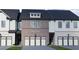 Charming brick and siding townhome with a two-car garage and a well-manicured lawn at 293 Depot Landing Rd, Auburn, GA 30011