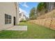 Picture of the backyard with a wooden retaining wall and patio near the house at 3920 Cain Mill Dr, Lithonia, GA 30038