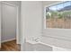 Bright bathroom showcasing a large soaking tub with window views and access to the walk-in closet at 3920 Cain Mill Dr, Lithonia, GA 30038