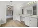 Bathroom featuring double sinks, a large mirror with vanity lighting, and wood look floors at 3920 Cain Mill Dr, Lithonia, GA 30038