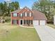 Charming two-story brick home with a well-manicured lawn and a two-car garage at 3920 Cain Mill Dr, Lithonia, GA 30038