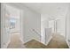 Upstairs hallway boasts neutral colors, a staircase, and entryways to multiple rooms at 3920 Cain Mill Dr, Lithonia, GA 30038