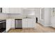 Modern kitchen featuring white cabinets, stainless steel appliances, and wood-look floors at 3920 Cain Mill Dr, Lithonia, GA 30038