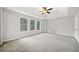 Spacious primary bedroom has large windows, plush carpeting and a ceiling fan at 3920 Cain Mill Dr, Lithonia, GA 30038