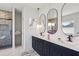 Bathroom with double vanity, dark blue cabinets, marble countertops, and tiled shower at 482 Majestic Oaks Pl, Smyrna, GA 30082