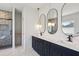 Bathroom with double vanity, dark blue cabinets, marble countertops, and tiled shower at 482 Majestic Oaks Pl, Smyrna, GA 30082