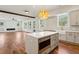 Open kitchen and living room featuring a center island with seating, stainless steel appliances, and ample natural light at 482 Majestic Oaks Pl, Smyrna, GA 30082