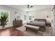 Staged primary bedroom with wood floors, bench at foot of bed, modern furniture, and large windows at 482 Majestic Oaks Pl, Smyrna, GA 30082