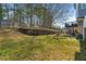 Large grassy backyard with a wooden retaining wall, play set and a partial view of the deck at 633 Windy Mill Xing, Temple, GA 30179