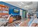 Cozy living room with blue walls, TV, hardwood floors, a plush couch and workspace at 633 Windy Mill Xing, Temple, GA 30179