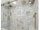 Modern bathroom featuring a glass shower with gold fixtures and elegant marble tiling at 6337 Lake View Dr, Buford, GA 30518