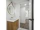 A powder room with modern round mirror and floating wood cabinet at 6337 Lake View Dr, Buford, GA 30518