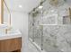 Large glass enclosed shower with white herringbone tile, marble floors, and a double vanity at 6337 Lake View Dr, Buford, GA 30518
