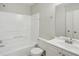 Bathroom features a tub with shower, toilet, mirror, and single sink vanity at 7004 Panda Ln, Austell, GA 30168