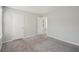 A bright bedroom with neutral paint, plush gray carpet, and two closets providing ample storage space at 7004 Panda Ln, Austell, GA 30168