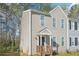 Two-story home with beige siding, black door, covered porch, and manicured lawn at 7004 Panda Ln, Austell, GA 30168