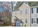 Two-story home with beige siding, black door, covered porch, and small front lawn at 7004 Panda Ln, Austell, GA 30168