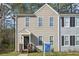 Two-story home with beige siding, black door, covered porch, and manicured lawn at 7004 Panda Ln, Austell, GA 30168