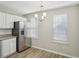 Eat-in kitchen features white cabinets, stainless steel appliances, and luxury vinyl flooring at 7004 Panda Ln, Austell, GA 30168
