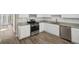 Well-lit kitchen features stainless steel appliances, granite counters, white cabinets, and wood-look flooring at 7004 Panda Ln, Austell, GA 30168