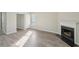Open living room with luxury vinyl floors, fireplace, and view into the dining room at 7004 Panda Ln, Austell, GA 30168