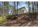 Back exterior view of a home with a patio, surrounded by mature trees and foliage at 2374 Buchanan Hwy, Dallas, GA 30157