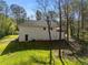 Back exterior showcasing brick facade, back door, and patio area with mature trees surrounding the home at 2374 Buchanan Hwy, Dallas, GA 30157