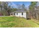 A single-story white home with a convenient carport on a well-manicured lot surrounded by trees at 2374 Buchanan Hwy, Dallas, GA 30157